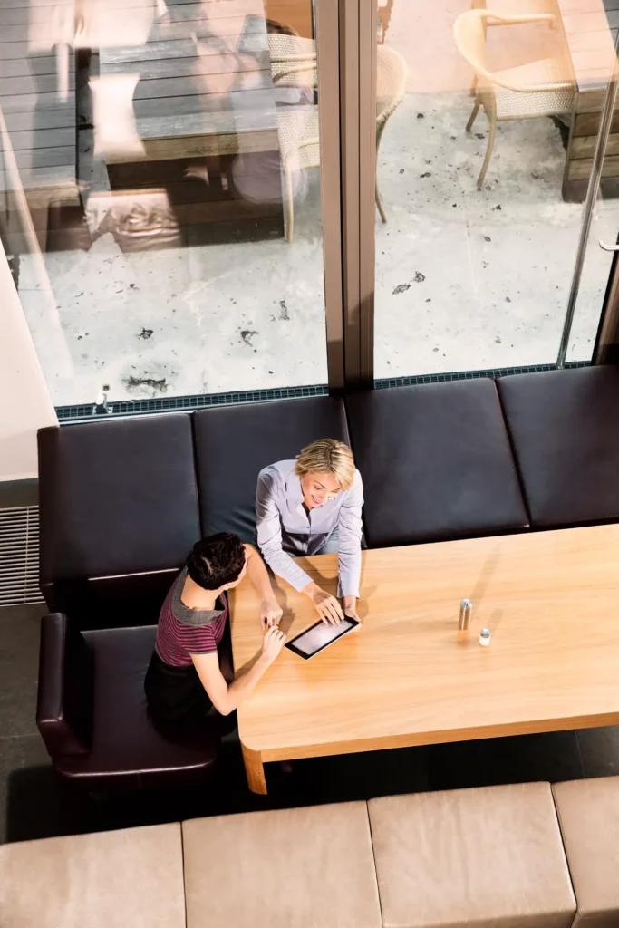 Two women reviewing tablet at restaurant booth