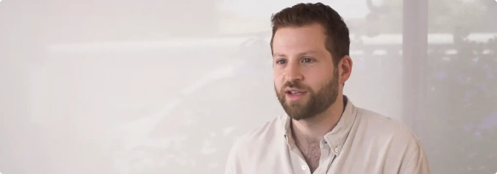 Bearded man speaking indoors against blurred background