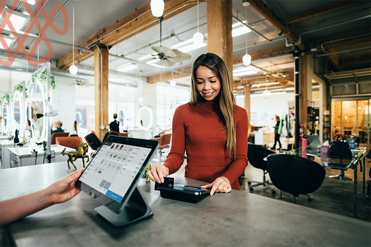 Woman making contactless payment at modern salon counter
