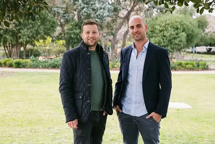Two men standing together in a park