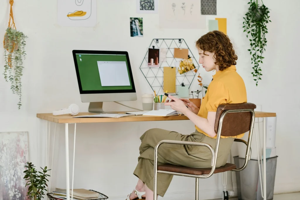 Woman using smartphone at minimalist home office desk