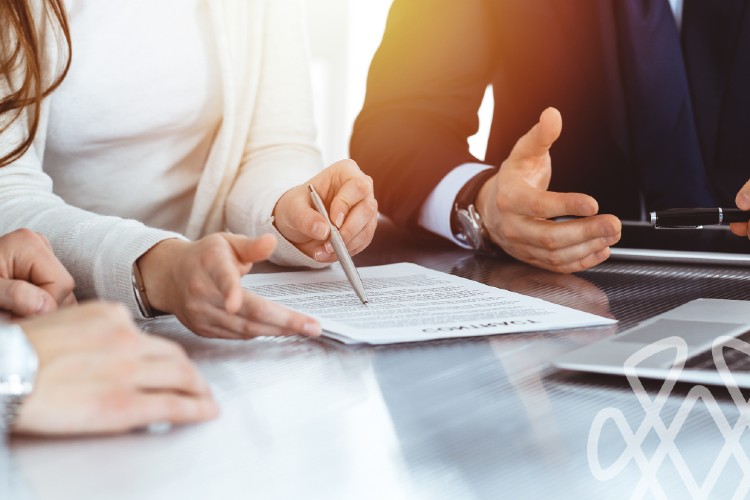 Business professionals reviewing and signing contract at desk