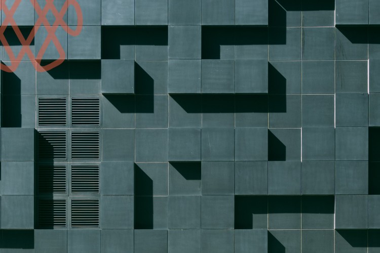 Abstract geometric building facade with vents and shadows
